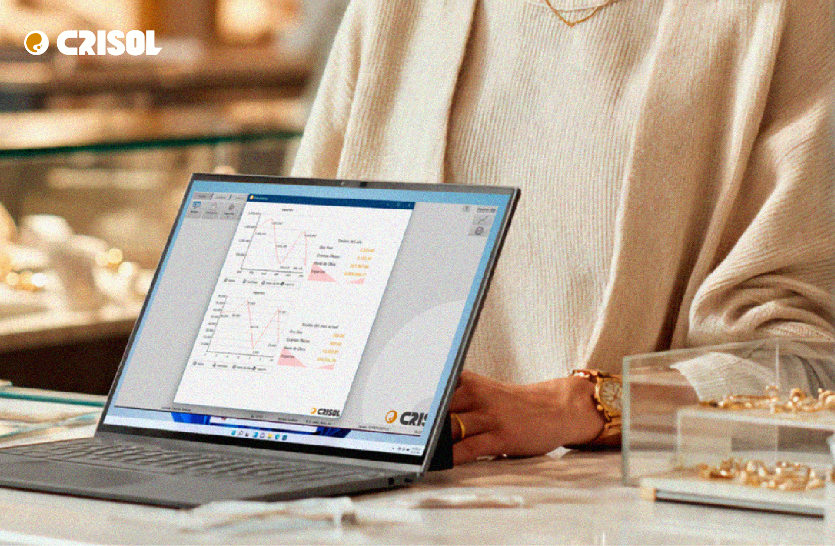 Joyero revisando información de inventarios y reportes en el sistema Crisol desde una laptop dentro de una joyería.