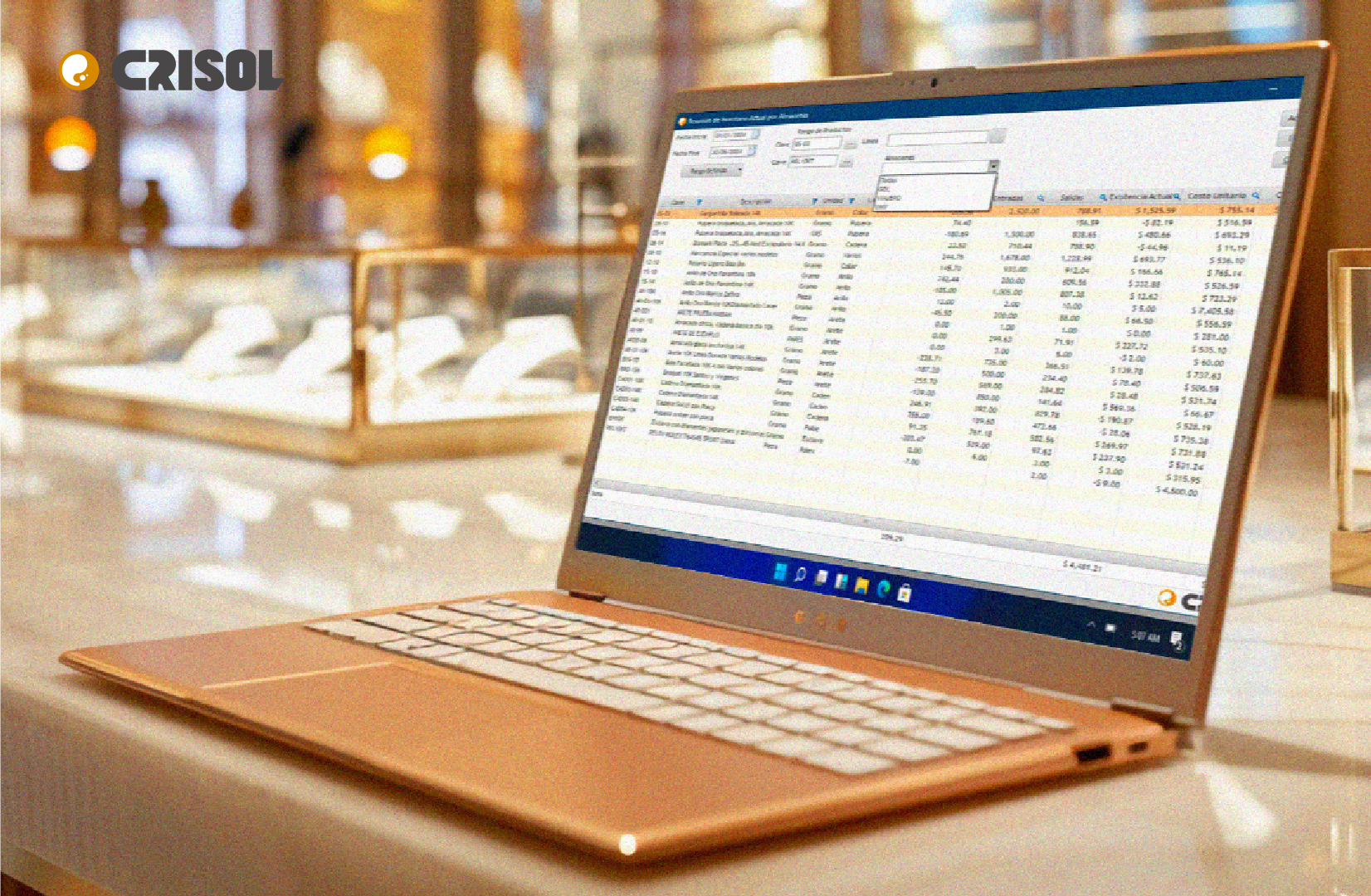 Computadora portátil con el sistema Crisol mostrando un reporte de inventarios y existencias de joyería en un entorno de tienda.